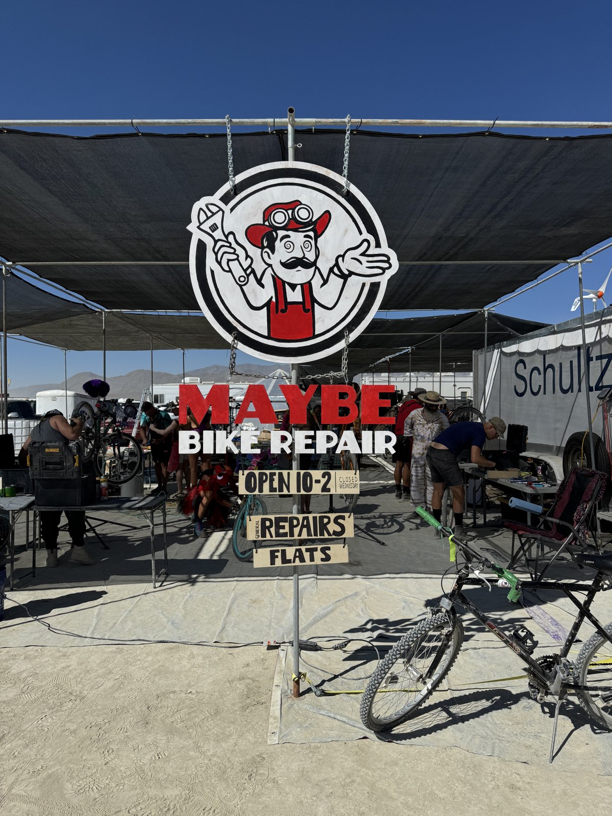 Maybe Bike Repair camp entrance on playa with hours posted